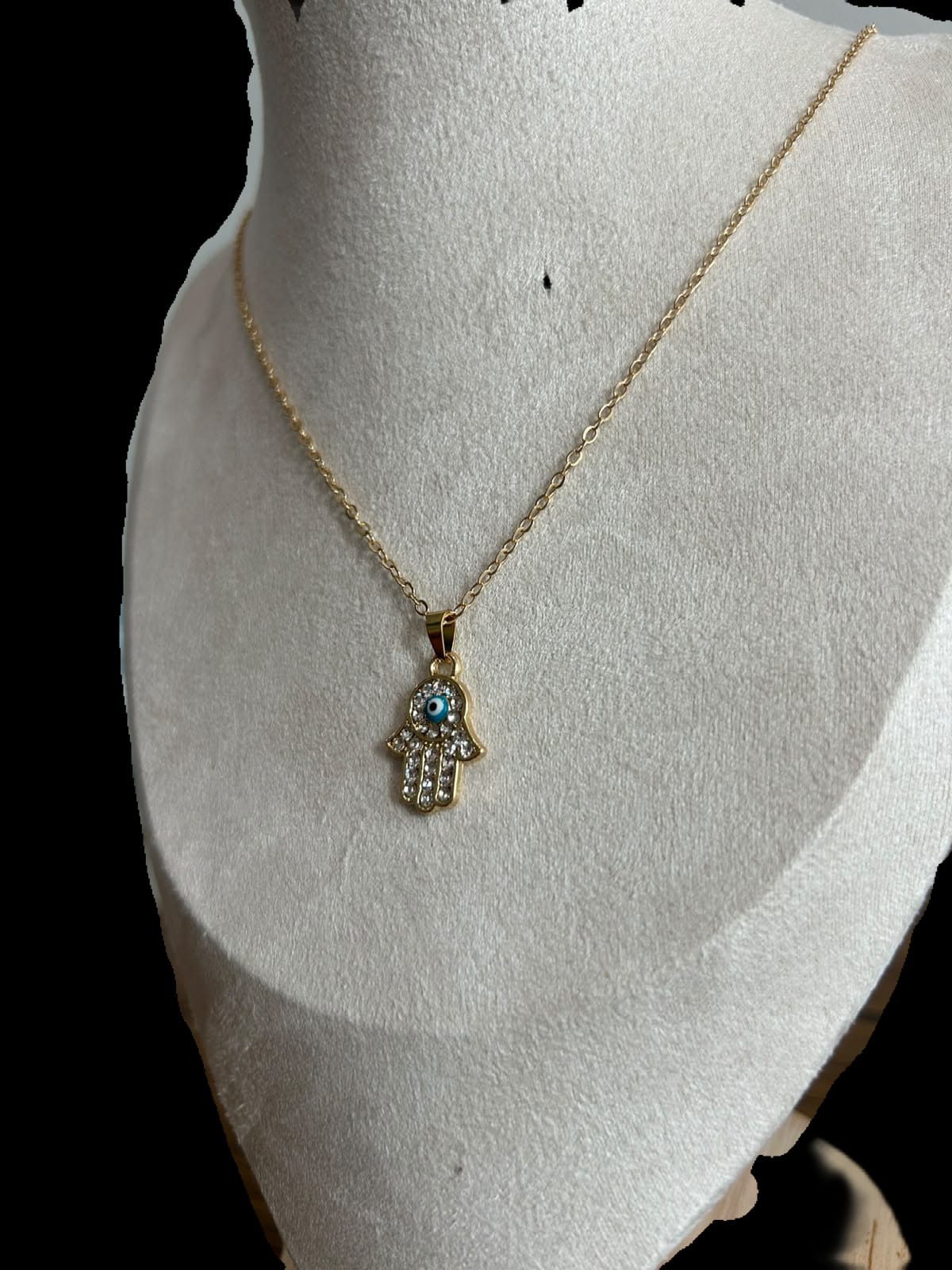 Collar pequeño, mano y ojo azul claro.oro