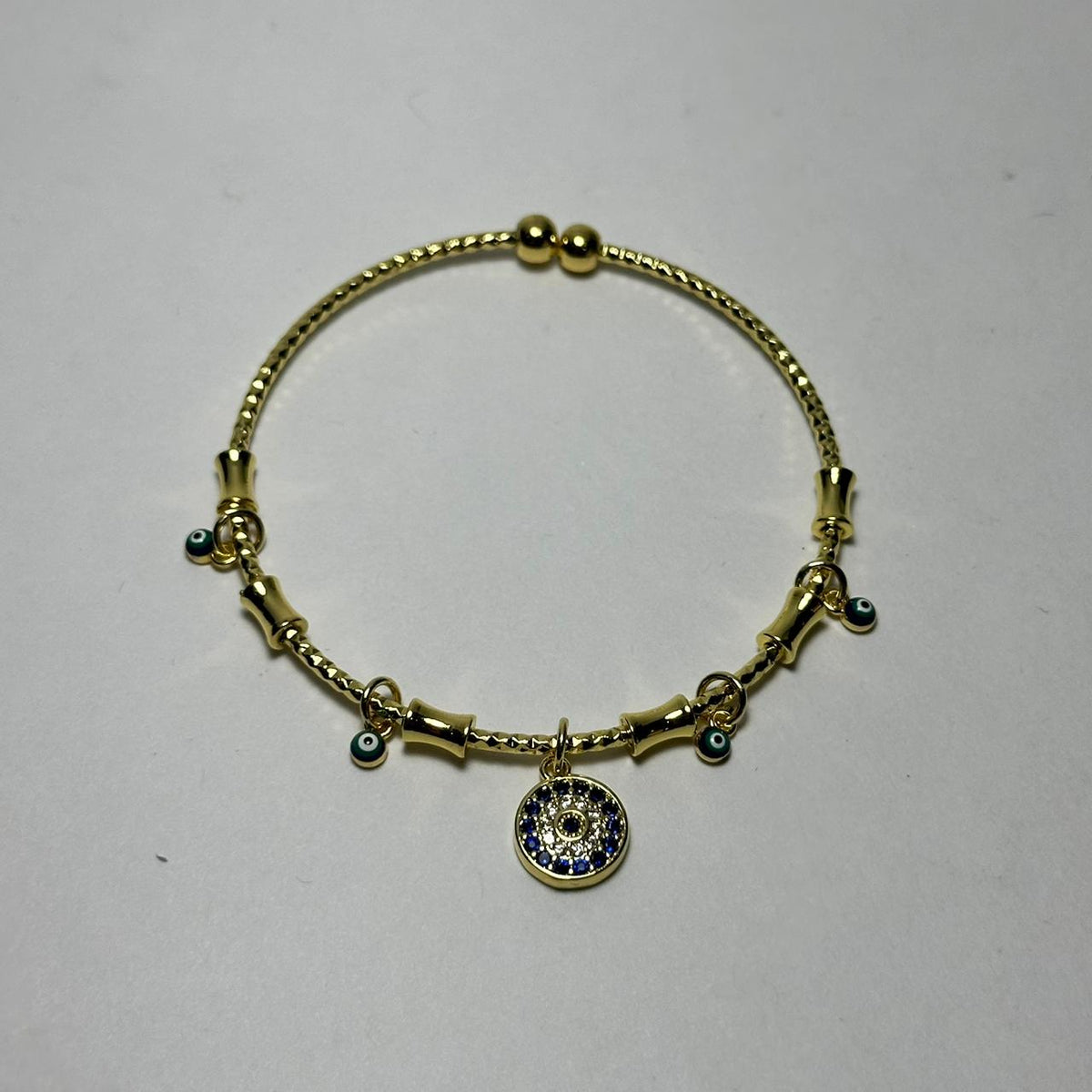 Pulsera abierta ojo redondo azul marino en medio.oro