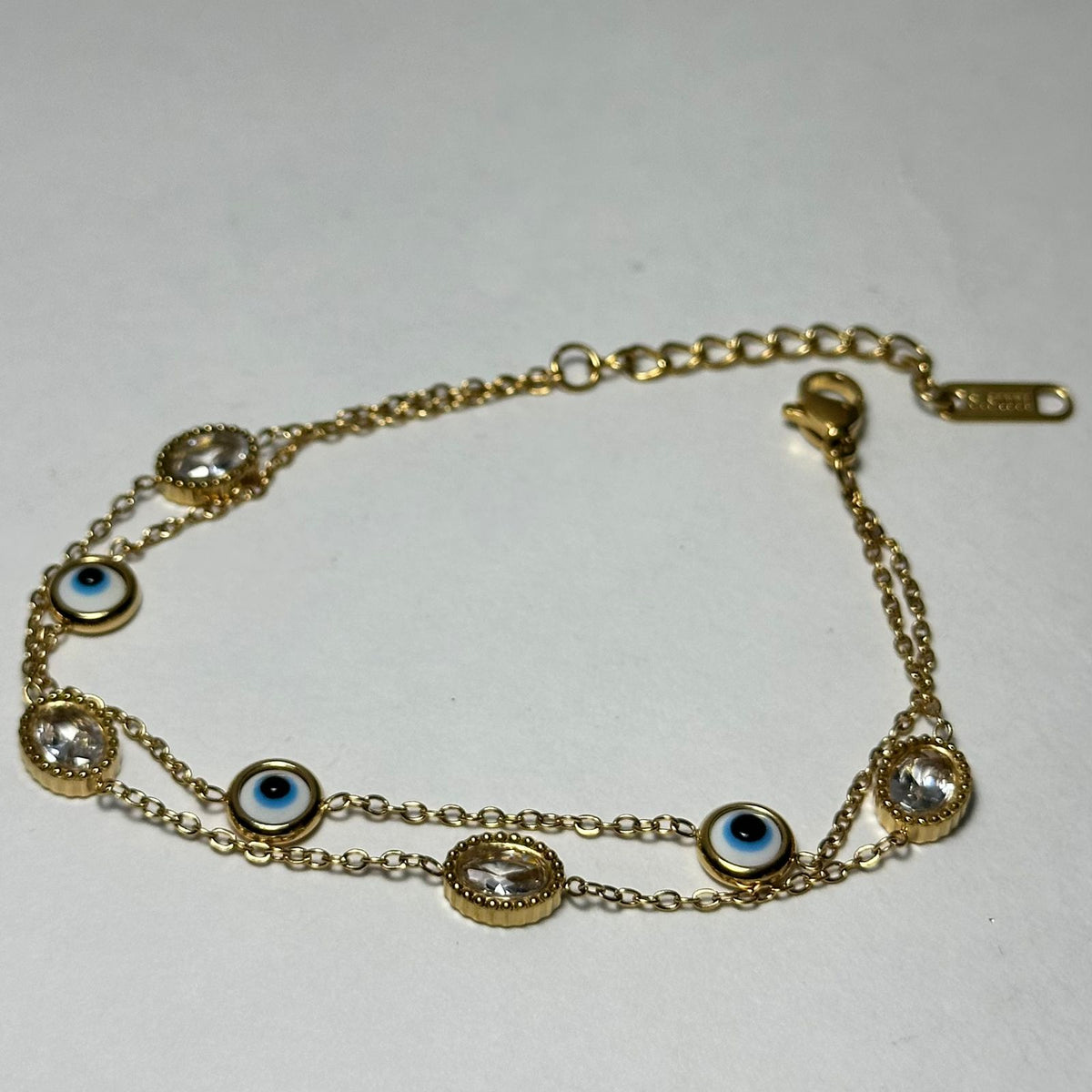 Pulsera doble con ojitos y piedras.oro