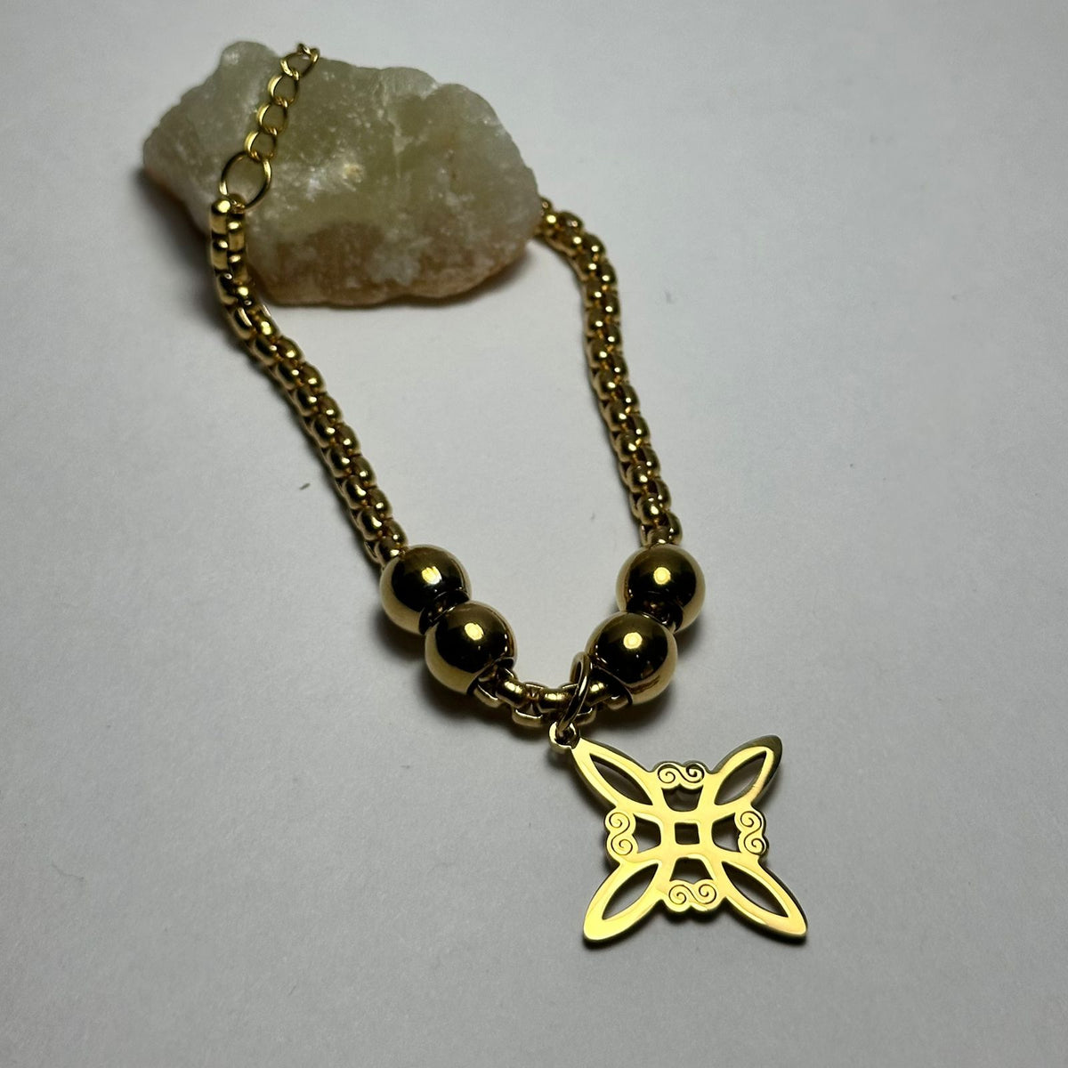 Pulsera nudo de bruja con bolitas grandes.oro