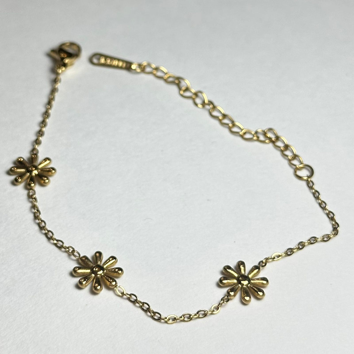 Pulsera sencilla con tres flores.oro